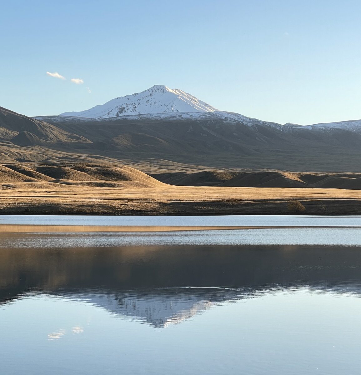 A mountain mirrored in still water, the reflection unbroken.