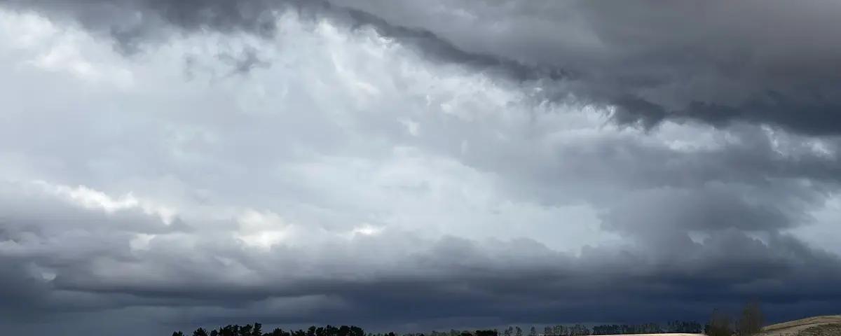Heavy cloud massing over flat farmland