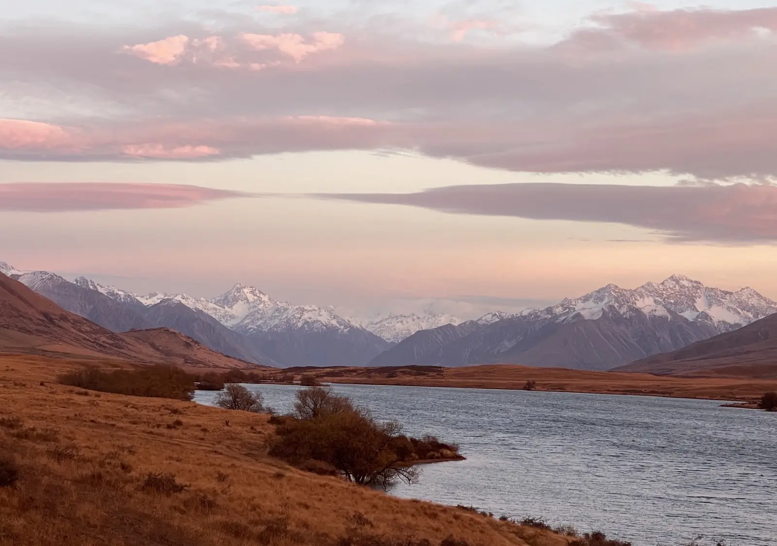 A high-country lake below snow peaks at dusk, Aotearoa New Zealand